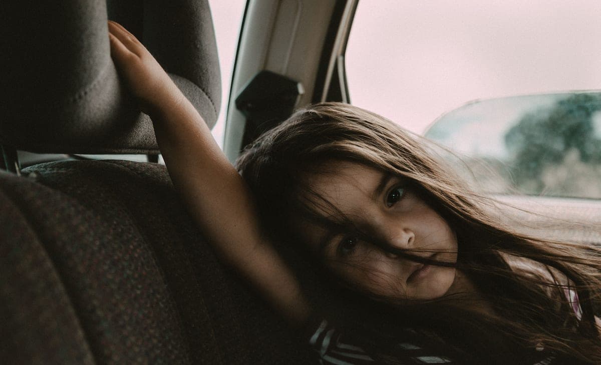 Children in the back seat of a car on a road trip