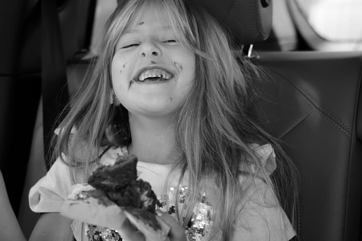 A child eating a snack in a car seat