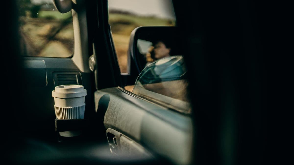 A reusable travel cup held in a car