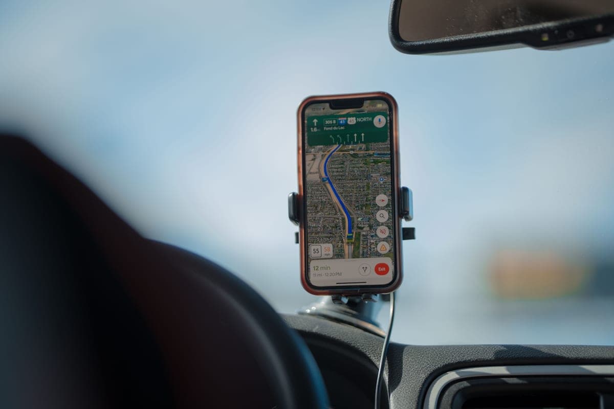 An iPhone mounted in a car showing a map