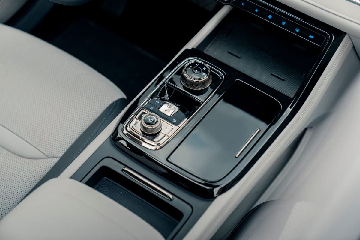 An open center console storage bin in a car