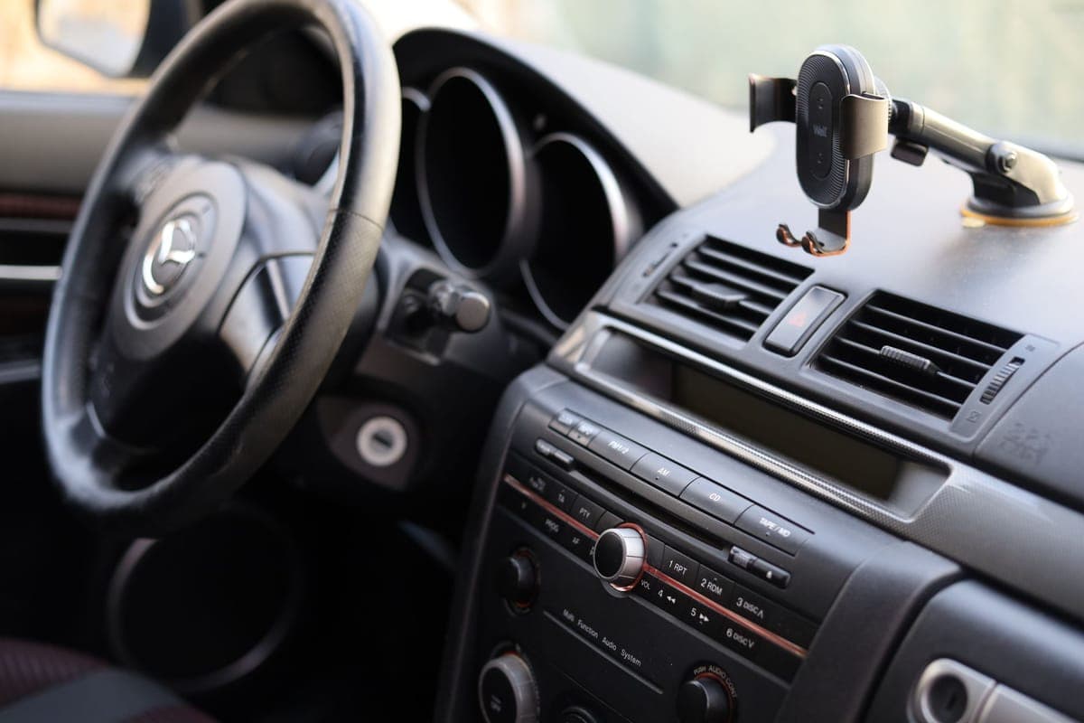 A car dashboard with a steering wheel and a phone