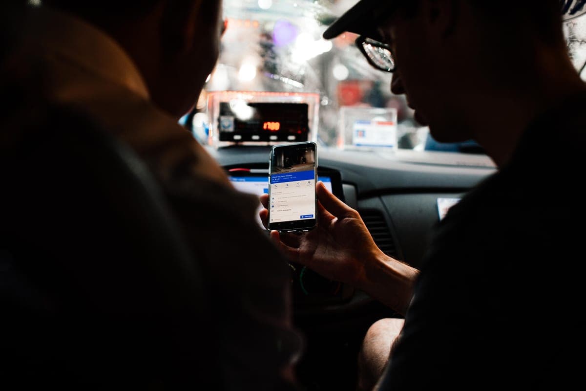 A rideshare driver with a passenger in the back of a car