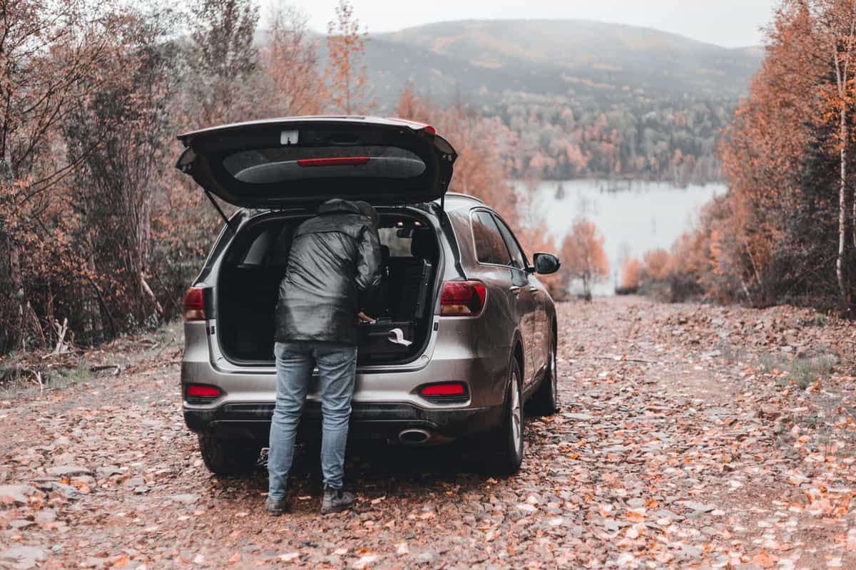 A person unloading gear from the open cargo area of an SUV