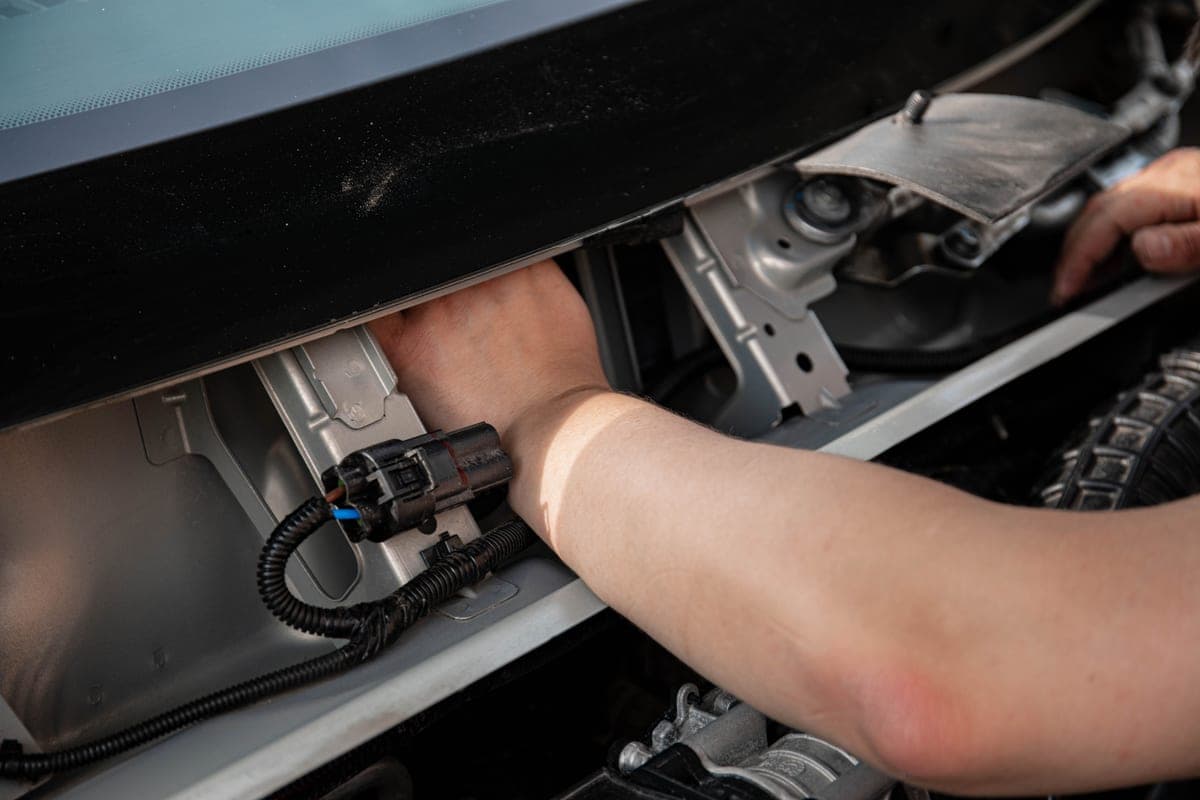 A car fuse box and wiring beneath the dashboard