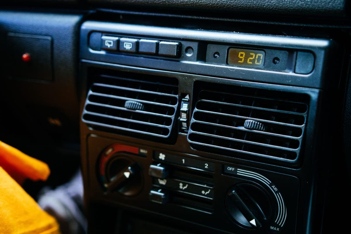 A hand adjusting a car air vent