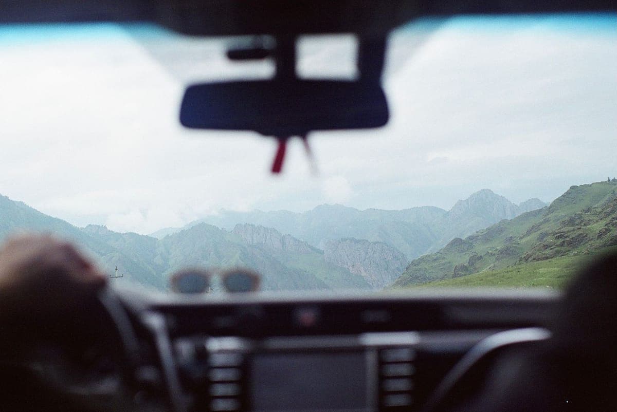 A mountain road seen through a car windshield