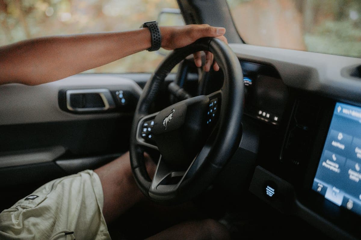 A driver's hands on a car steering wheel